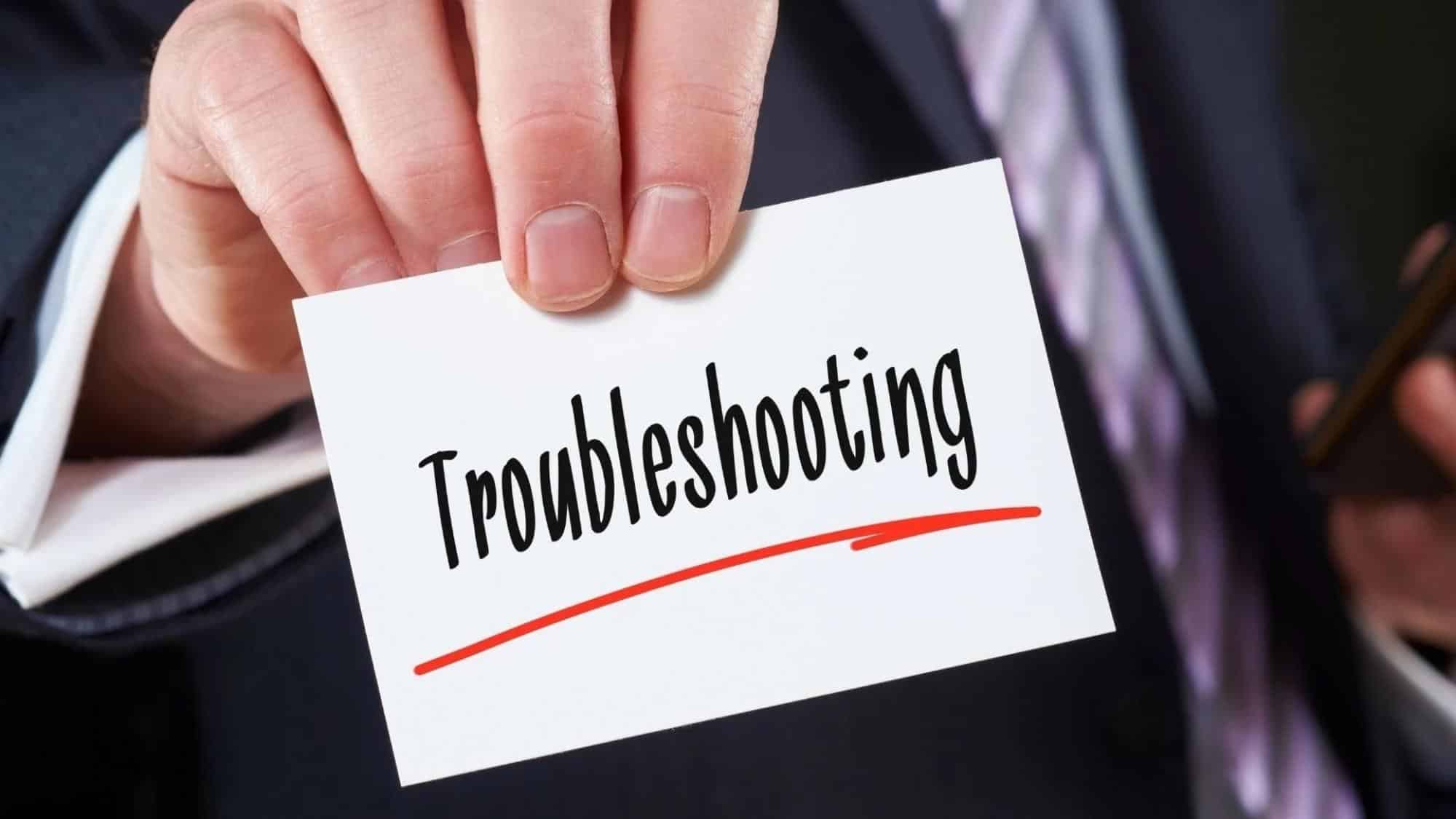  Person holding a card that says "troubleshooting" to figure out common HVAC issues with Moncrief Heating and Air Conditioning