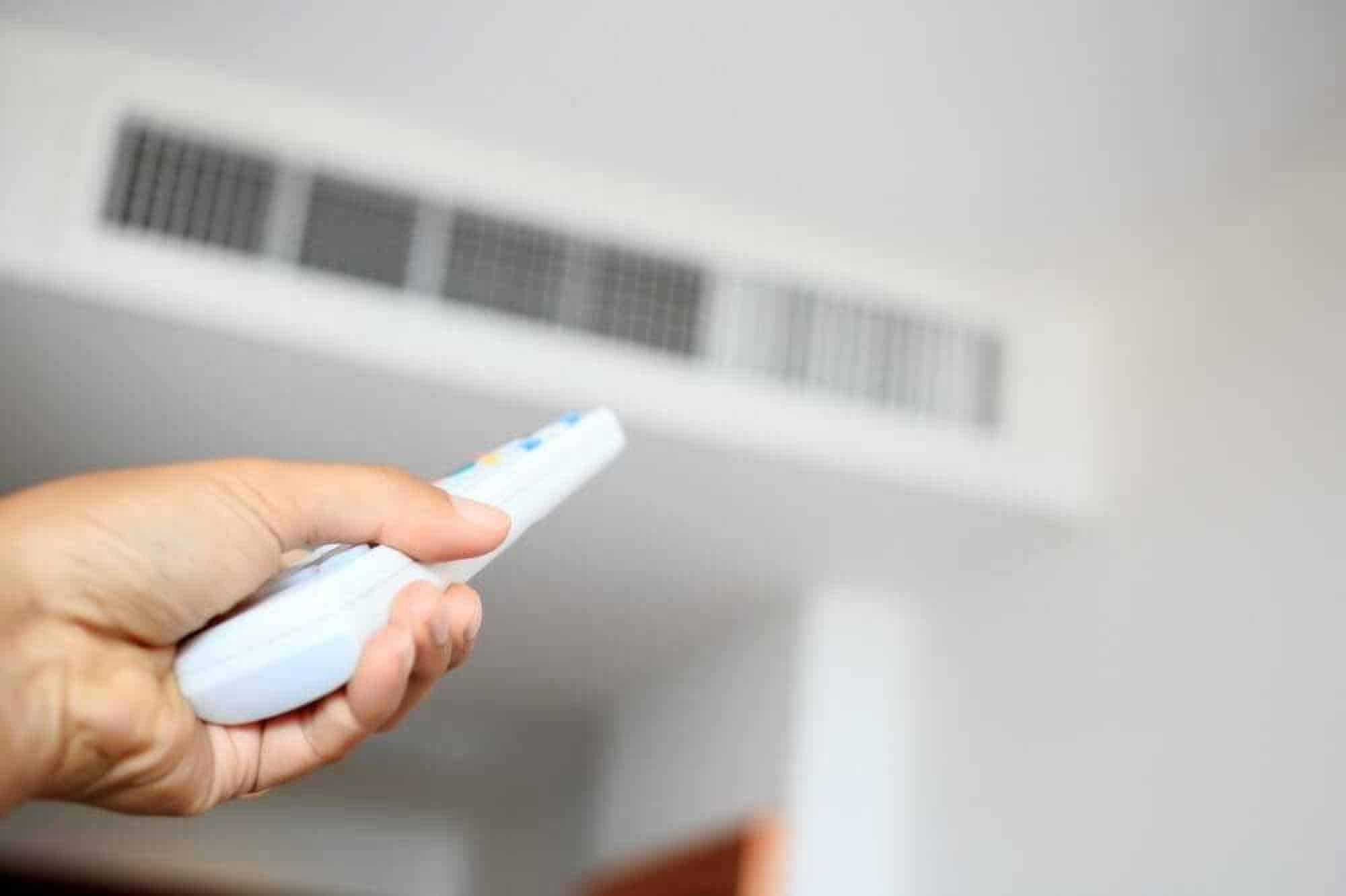 Person using remote control to control rooftop HVAC unit