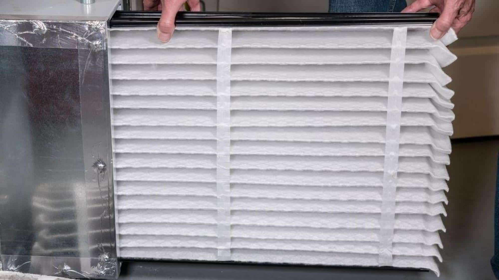 Moncrief Heating and Air Conditioning technician holding a clean air filter