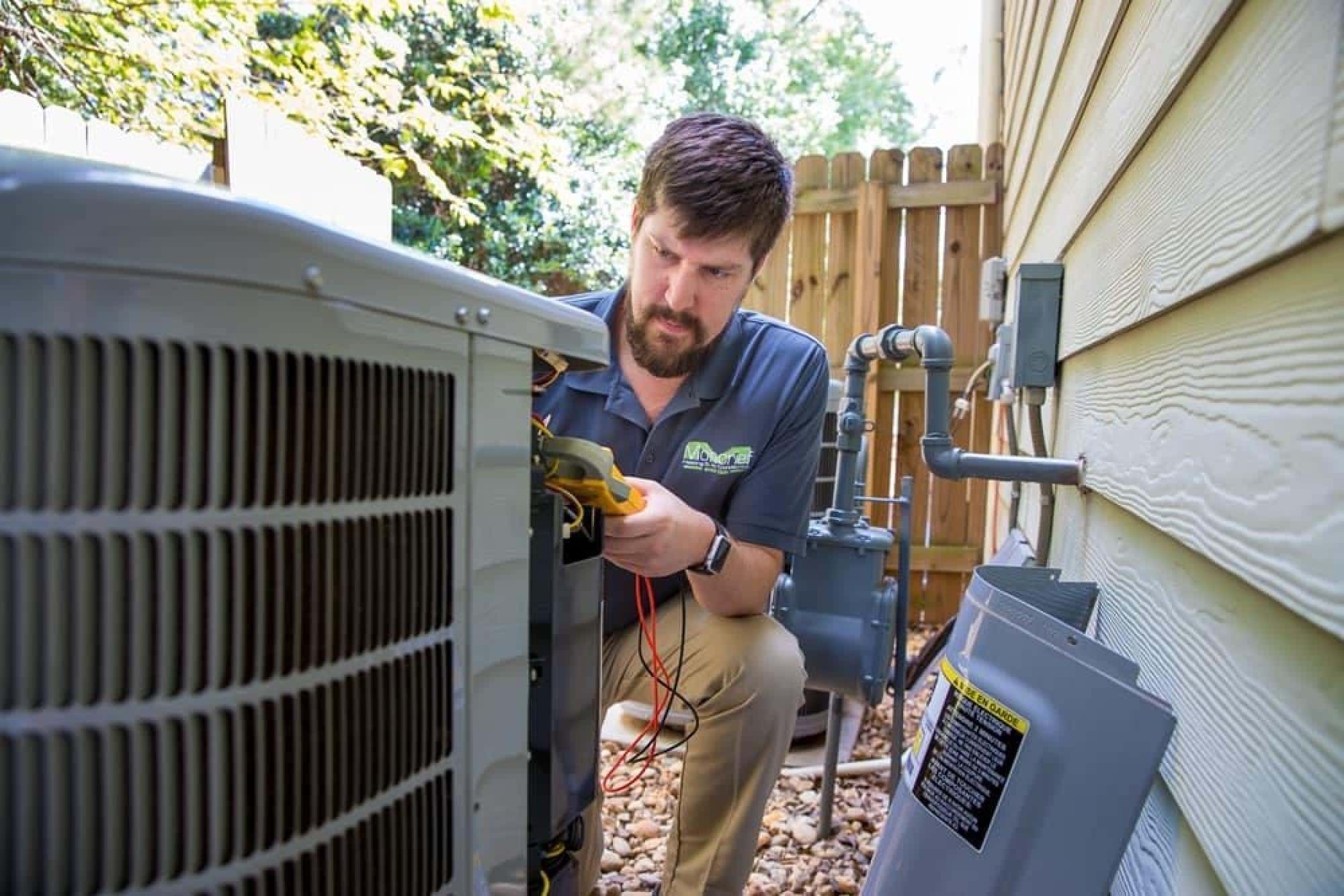Moncrief Technician Repairing an HVAC Unit With Tools in Hand