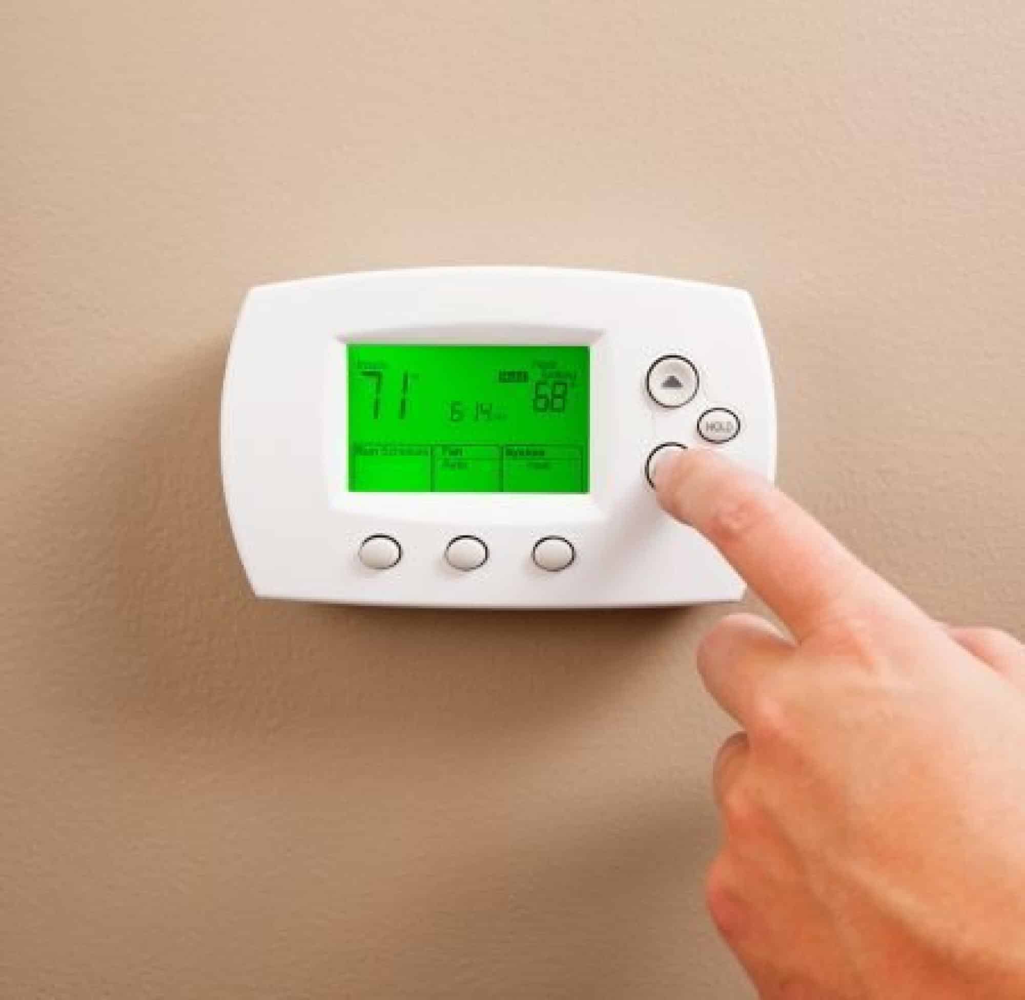 Person Adjusting Thermostat Settings