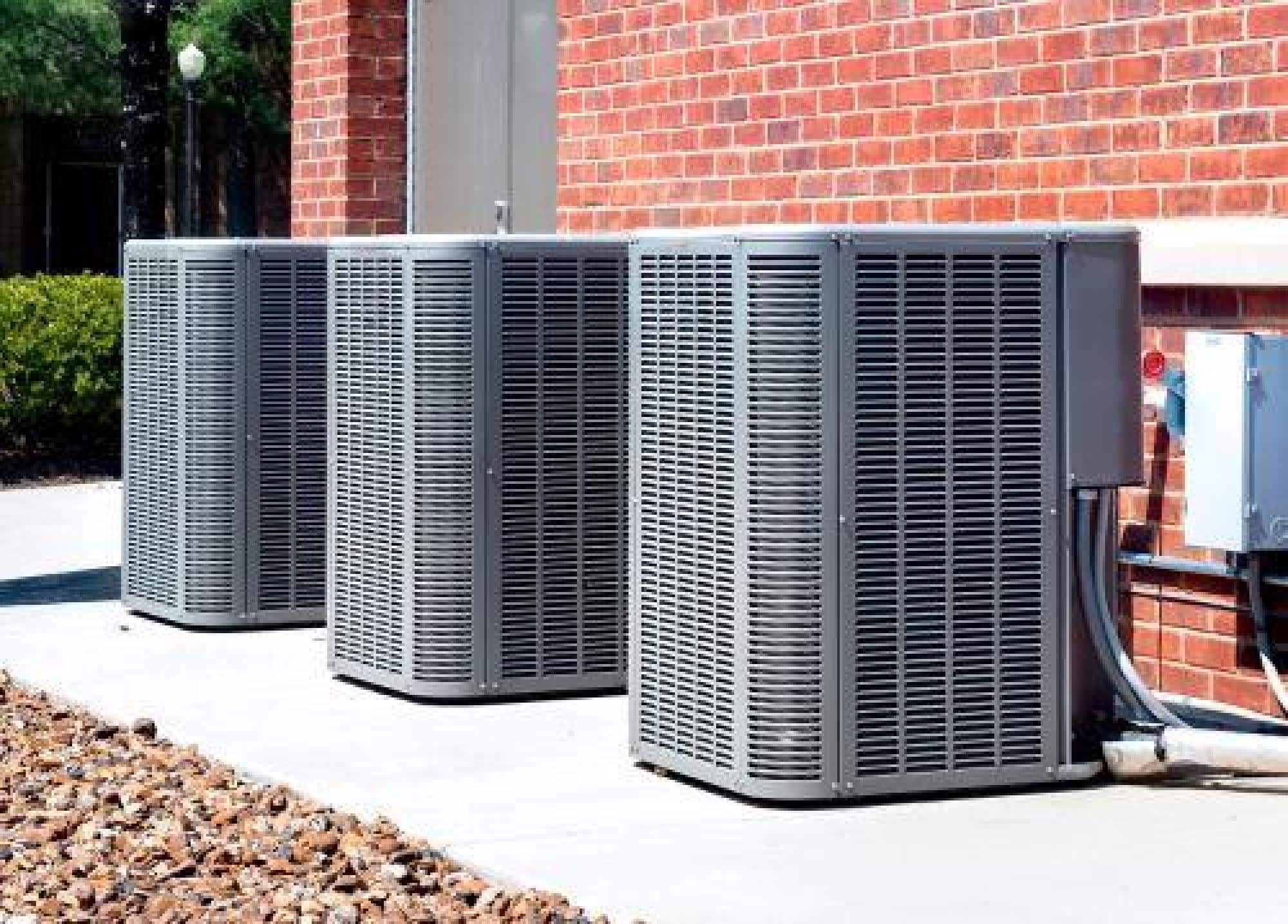 Three Outdoor HVAC Units Installed On Concrete Pads